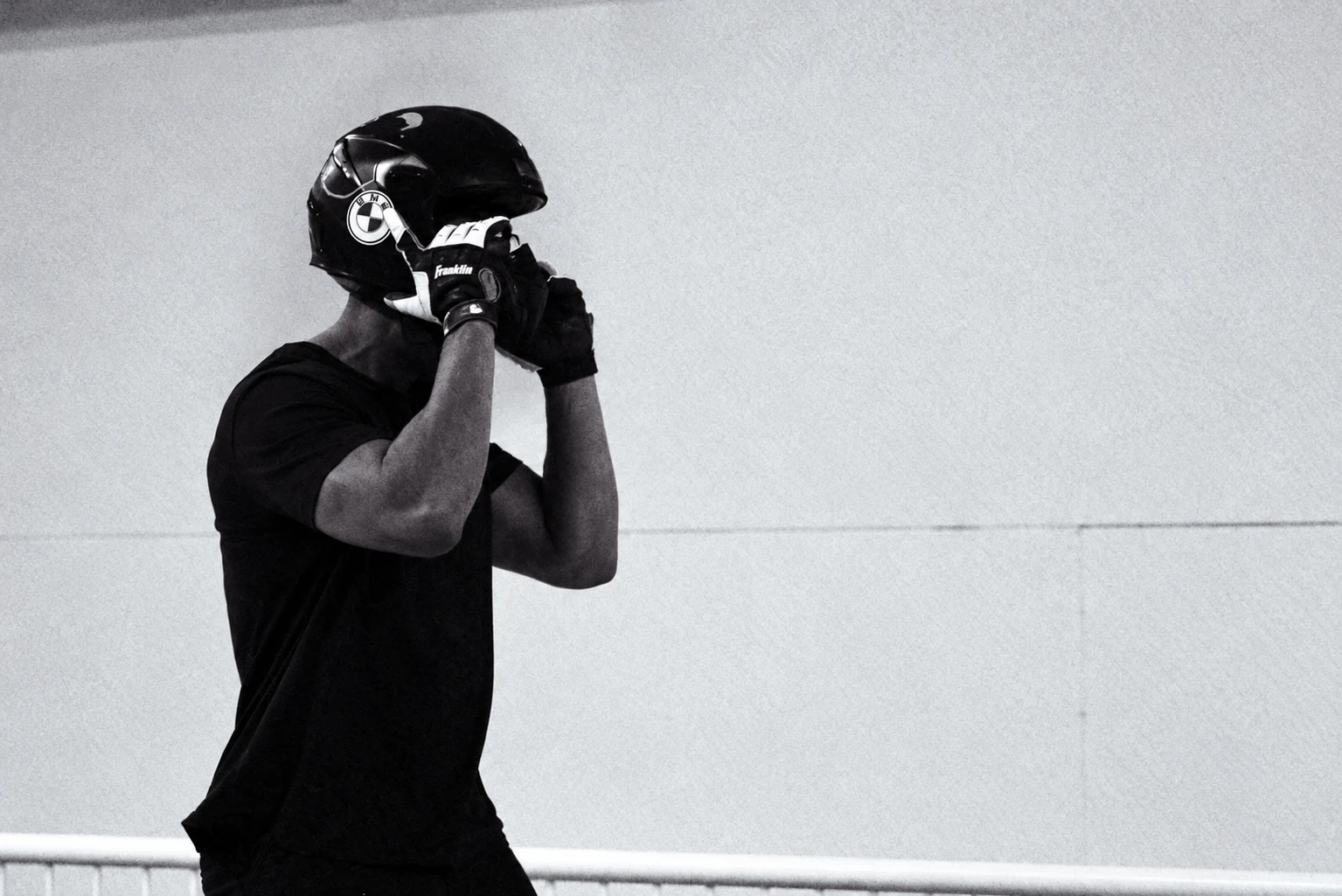 Black and white photograph of an athlete preparing a bobsled helmet